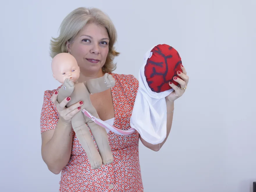 Docente com simulador neonatal e modelo de placenta