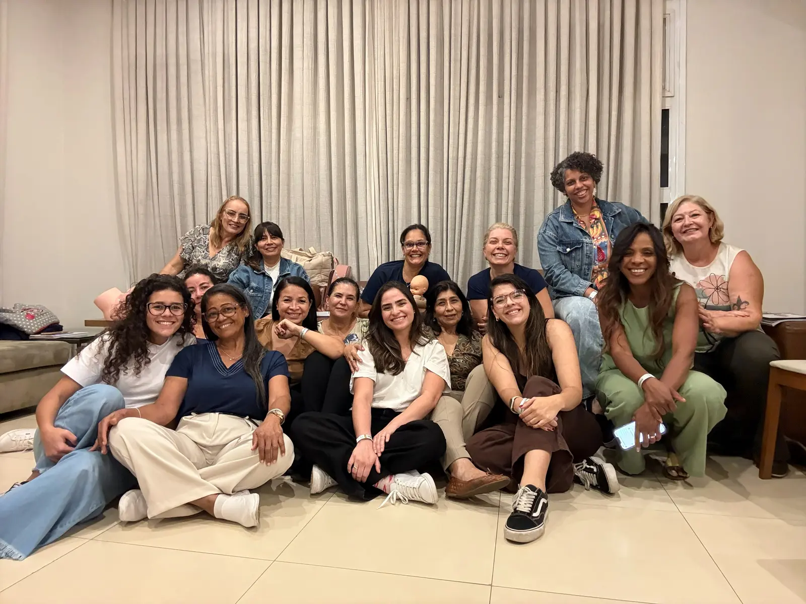A turma da edição anterior reunida no chão da sala, sorrindo para a câmera no fim do encontro.
